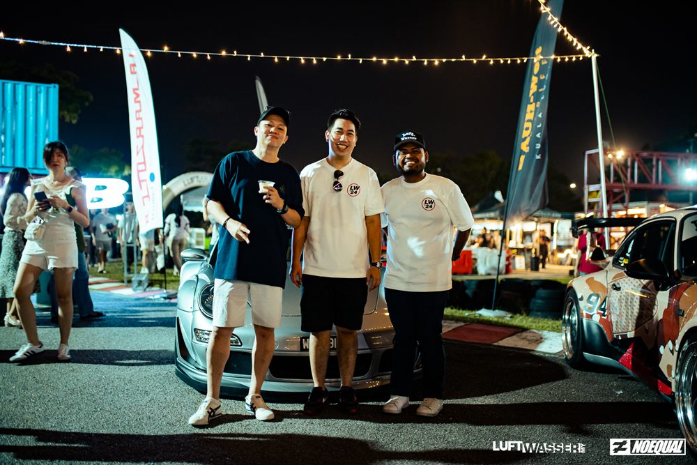 Three friends in LW24 tees under the string lights at night