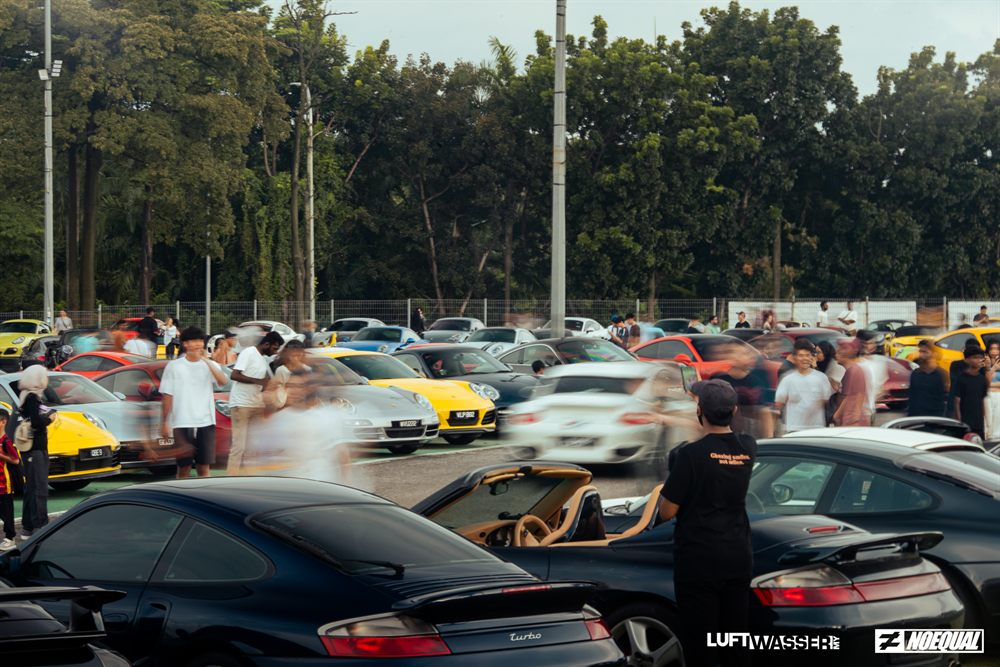 The crowd moving between rows of parked 911s